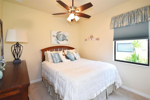 carpeted bedroom with a ceiling fan and baseboards