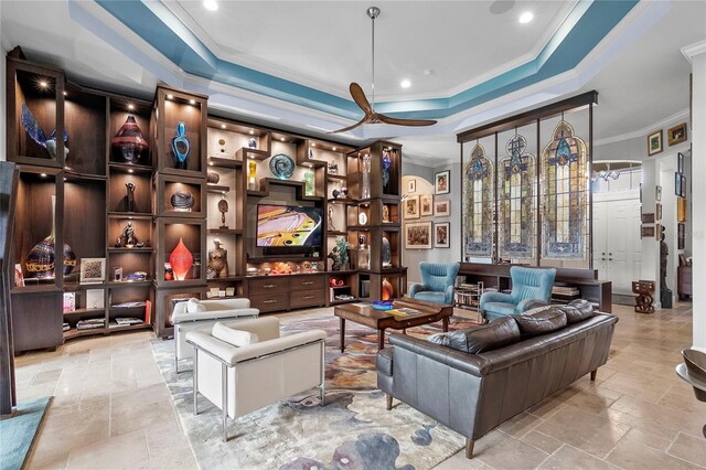 interior space featuring a tray ceiling, ornamental molding, ceiling fan, and light tile flooring