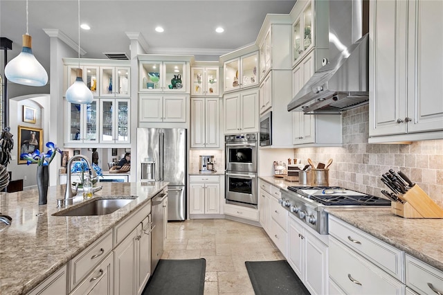 kitchen featuring crown molding, appliances with stainless steel finishes, wall chimney exhaust hood, pendant lighting, and light tile flooring