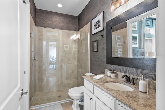 bathroom with an enclosed shower, vanity, toilet, and tile floors