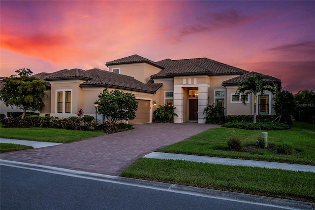 mediterranean / spanish house with a garage and a yard