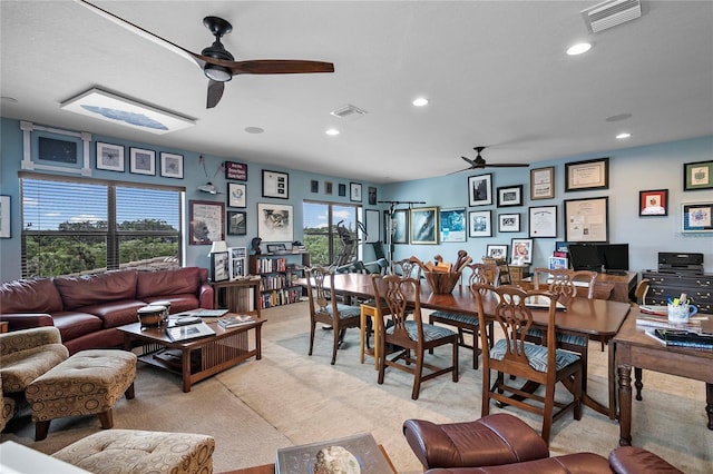 carpeted living room featuring ceiling fan and a wealth of natural light