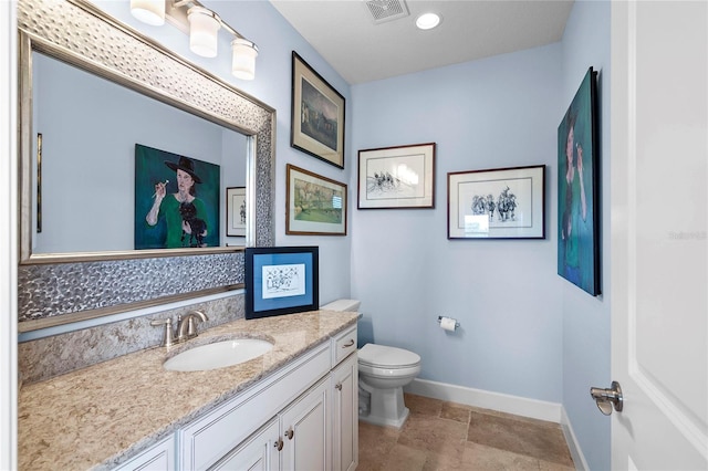 bathroom with tile flooring, toilet, and vanity