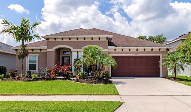 mediterranean / spanish-style home with a garage and a front lawn