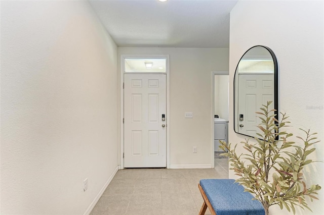 foyer entrance with light tile patterned flooring, a textured ceiling, and washer / clothes dryer