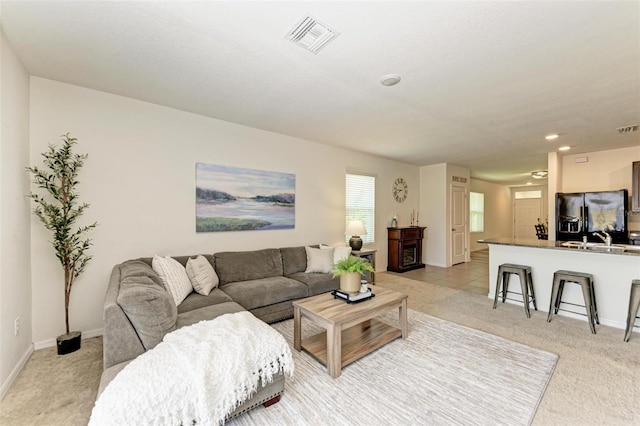 carpeted living room with sink