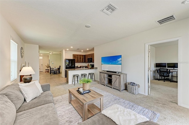 living room featuring light carpet and a textured ceiling