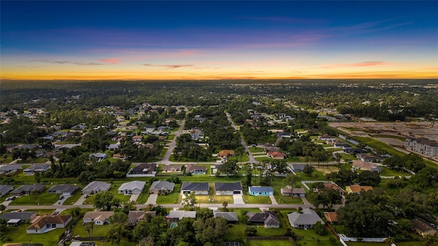 aerial view at dusk featuring a residential view