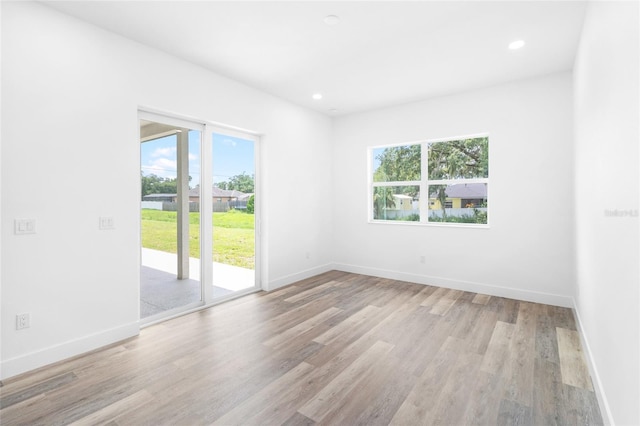 spare room featuring light wood-style floors, recessed lighting, and baseboards