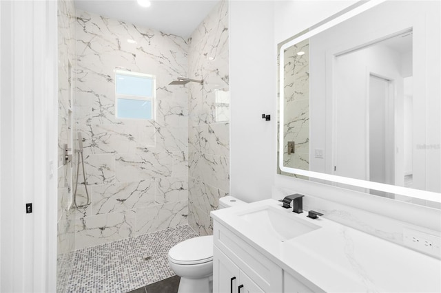 full bath with toilet, vanity, and a marble finish shower