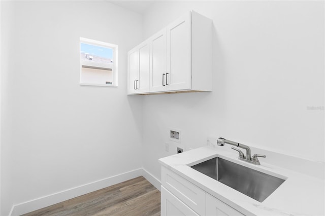 laundry area featuring washer hookup, cabinet space, a sink, electric dryer hookup, and baseboards