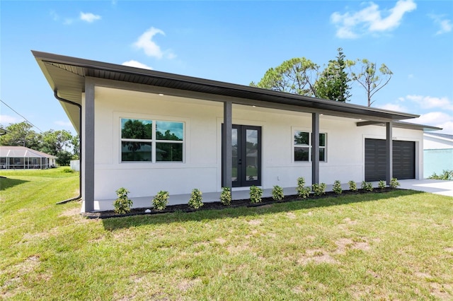 view of front of home with a garage, a front yard, french doors, and stucco siding