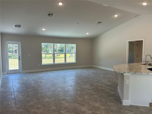 unfurnished living room featuring sink and vaulted ceiling