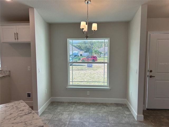 unfurnished dining area featuring a healthy amount of sunlight and an inviting chandelier