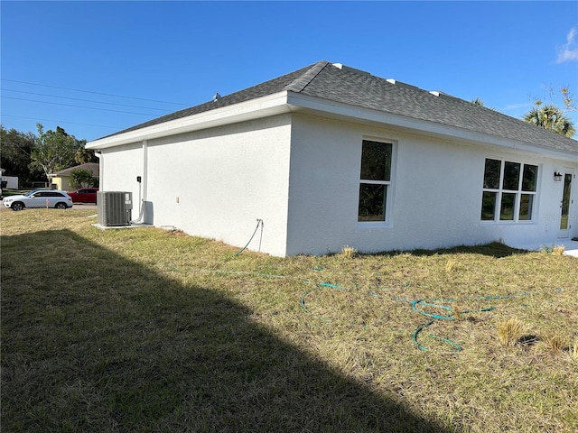 view of property exterior with a yard and central AC unit