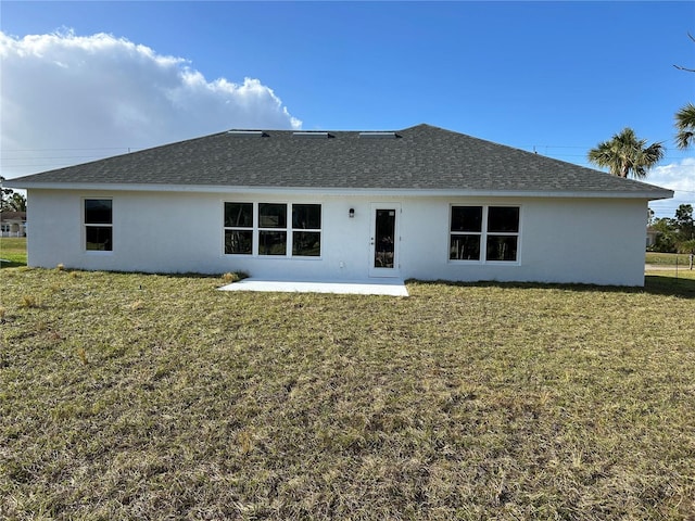 rear view of property with a yard and a patio