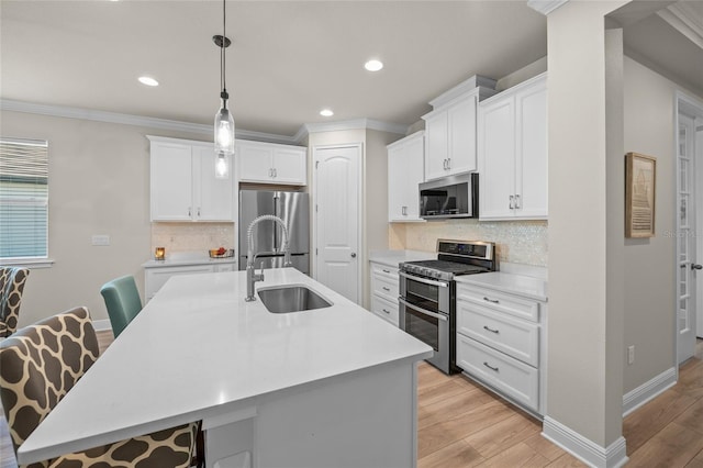 kitchen with a kitchen bar, stainless steel appliances, decorative light fixtures, light hardwood / wood-style flooring, and a center island with sink