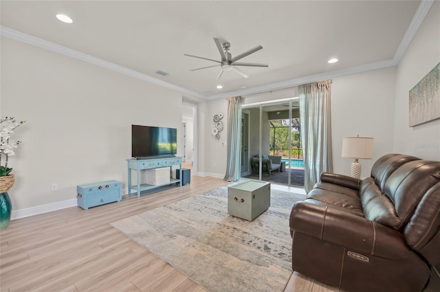 living room with light wood-type flooring, ceiling fan, and ornamental molding