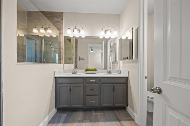 bathroom featuring vanity, ceiling fan, toilet, an enclosed shower, and wood-type flooring