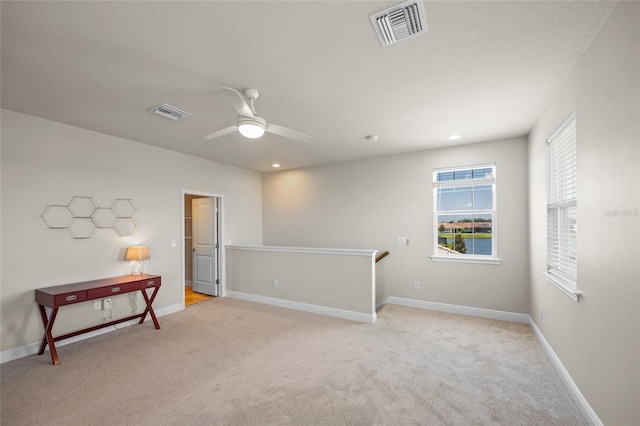 carpeted empty room featuring ceiling fan