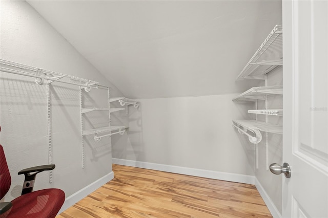 spacious closet with hardwood / wood-style flooring and lofted ceiling