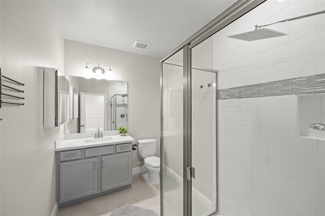 bathroom with tile patterned flooring, vanity, toilet, and an enclosed shower