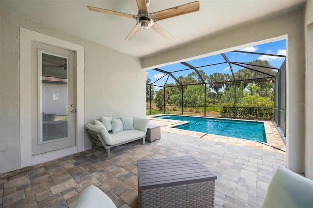 view of pool with a lanai, outdoor lounge area, ceiling fan, and a patio