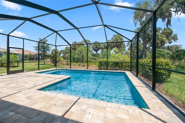 view of swimming pool with glass enclosure and a patio