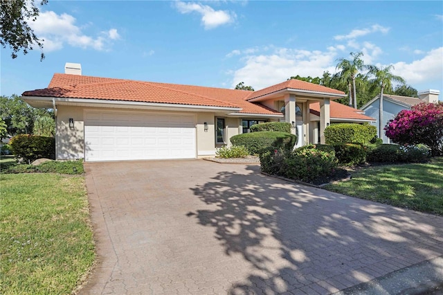 view of front of house featuring a garage and a front lawn