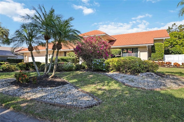 mediterranean / spanish-style house featuring a front yard and a garage