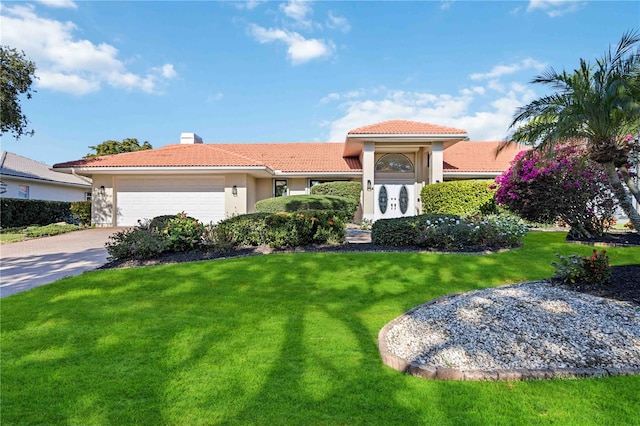 mediterranean / spanish home with a front lawn and a garage