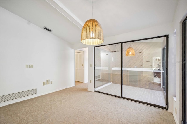 carpeted empty room featuring beam ceiling