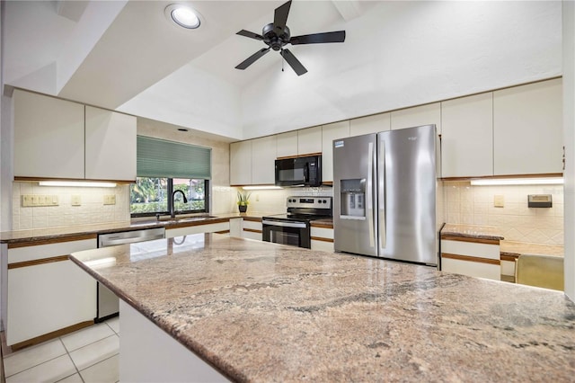 kitchen featuring light stone countertops, appliances with stainless steel finishes, ceiling fan, sink, and light tile patterned floors