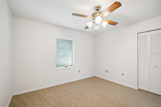 unfurnished bedroom featuring a closet, light colored carpet, and ceiling fan