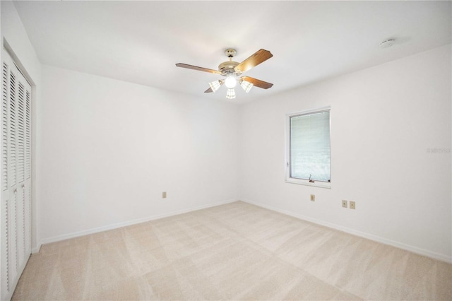 unfurnished bedroom with ceiling fan, a closet, and light colored carpet