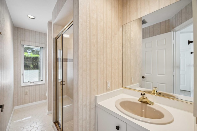 bathroom featuring tile patterned flooring, vanity, and walk in shower