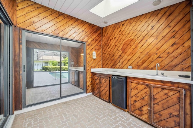 bar with a skylight, wood walls, sink, and refrigerator