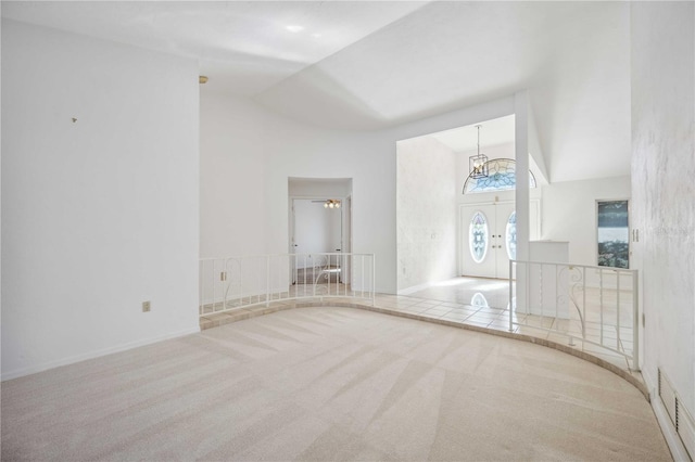 interior space with high vaulted ceiling, french doors, carpet floors, and a chandelier