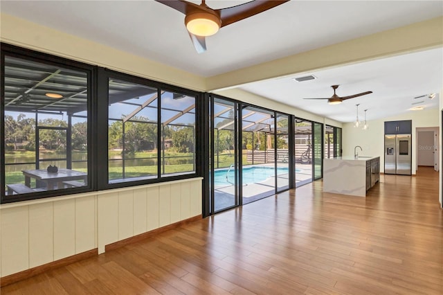 unfurnished room with hardwood / wood-style floors, vaulted ceiling, ceiling fan, and sink