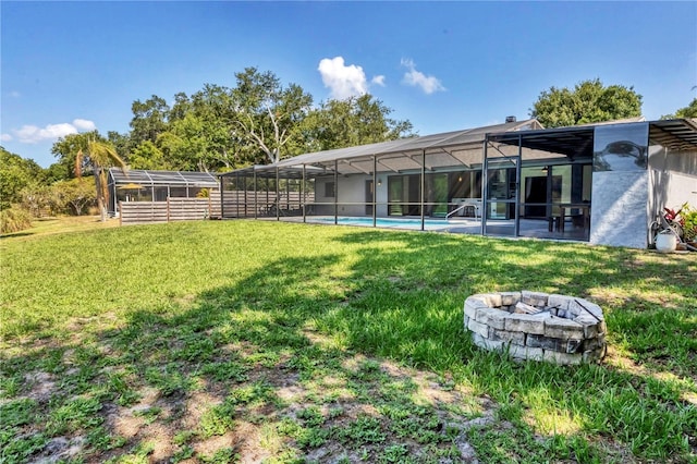 view of yard with a lanai and an outdoor fire pit