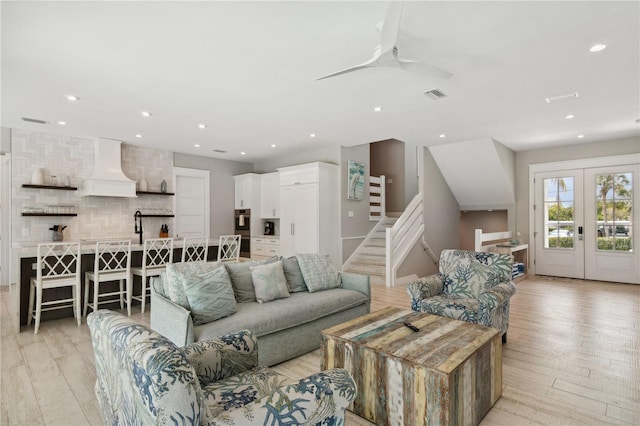 living room with ceiling fan, french doors, and light wood-type flooring