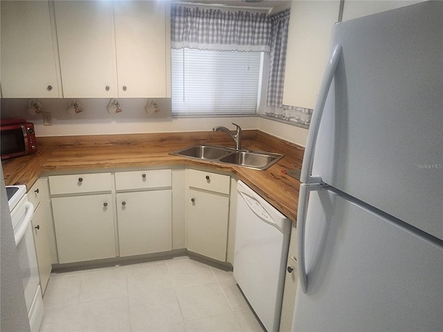 kitchen featuring butcher block counters, white appliances, and sink