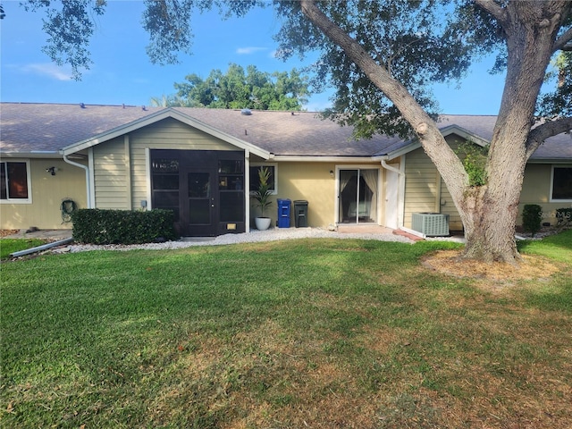 back of property featuring central air condition unit and a yard