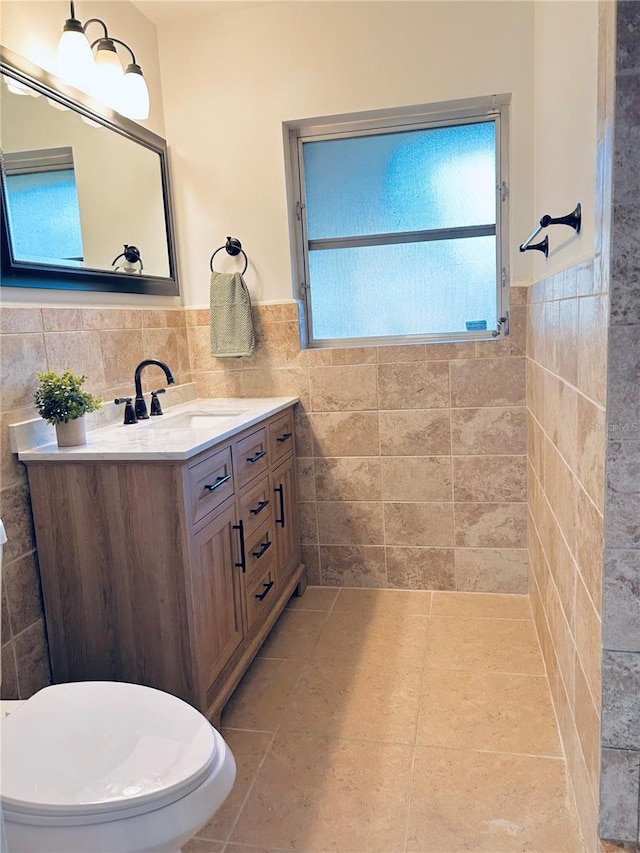 3637 Mineola Dr, Sarasota, FL 34239 - bathroom with tile walls, vanity, tile patterned flooring, and a wainscoted wall