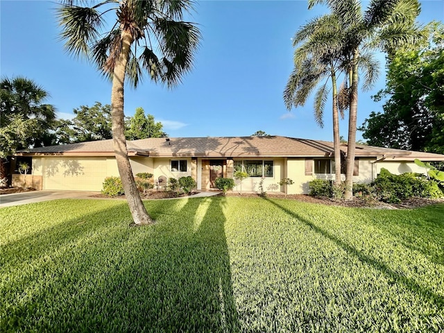 3637 Mineola Dr, Sarasota, FL 34239 - single story home featuring an attached garage, driveway, a front lawn, and stucco siding