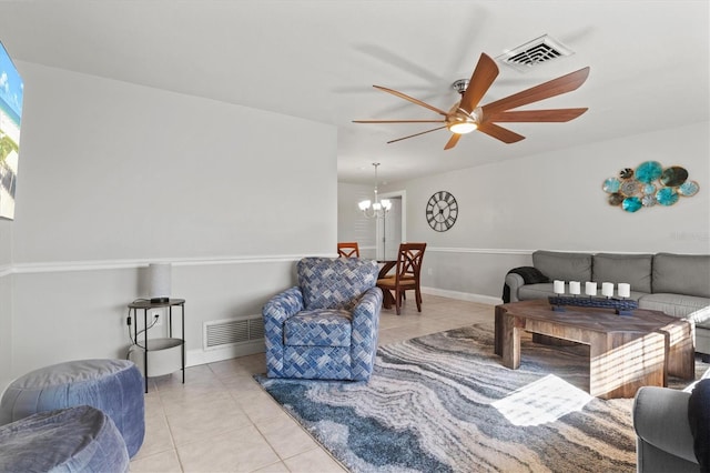 tiled living room with ceiling fan with notable chandelier