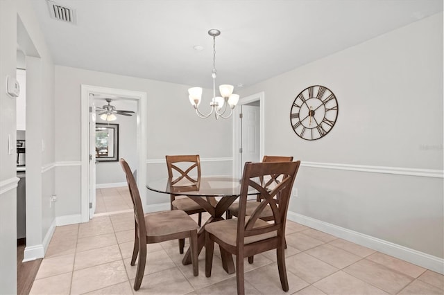 tiled dining room featuring ceiling fan with notable chandelier