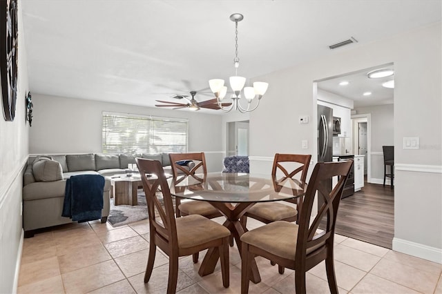 dining room featuring ceiling fan with notable chandelier and light tile floors