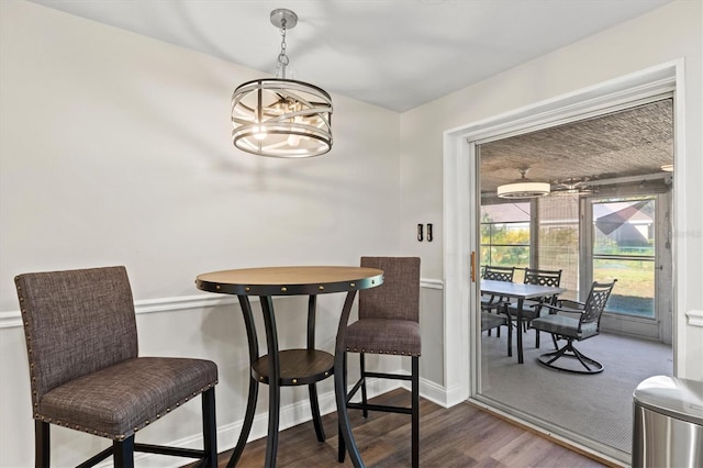 dining area featuring dark hardwood / wood-style flooring and a chandelier