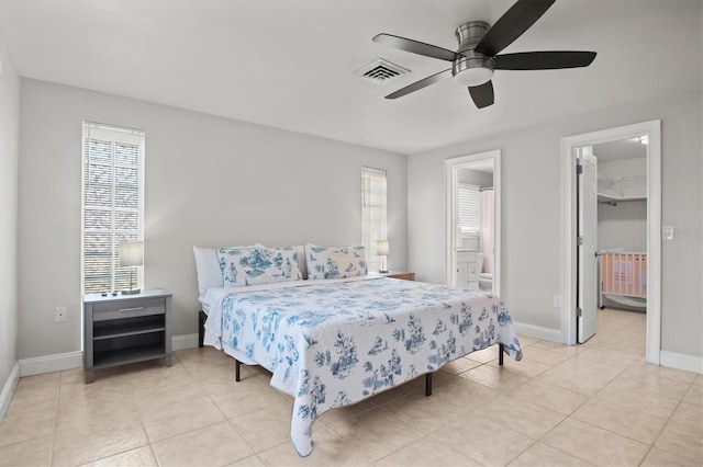 bedroom with ceiling fan, a closet, a spacious closet, light tile floors, and connected bathroom